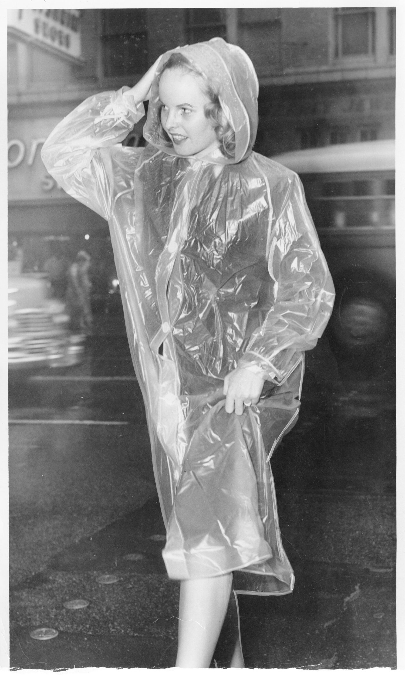 Mrs. Ernest Gallup dons a translucent raincoat during an October 1949 storm.
