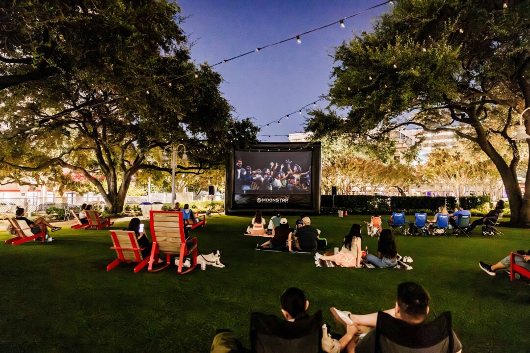 People enjoying a movie outside on the lawn at Market Square Park in Houston.