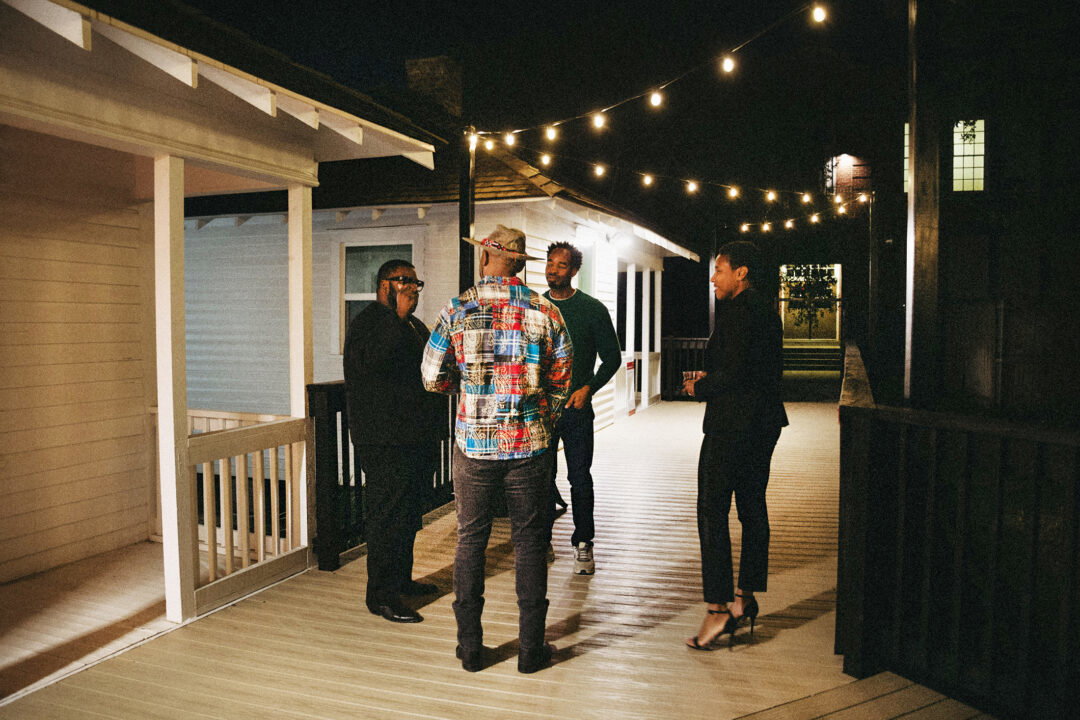 People standing in front of an old restored row house at night.