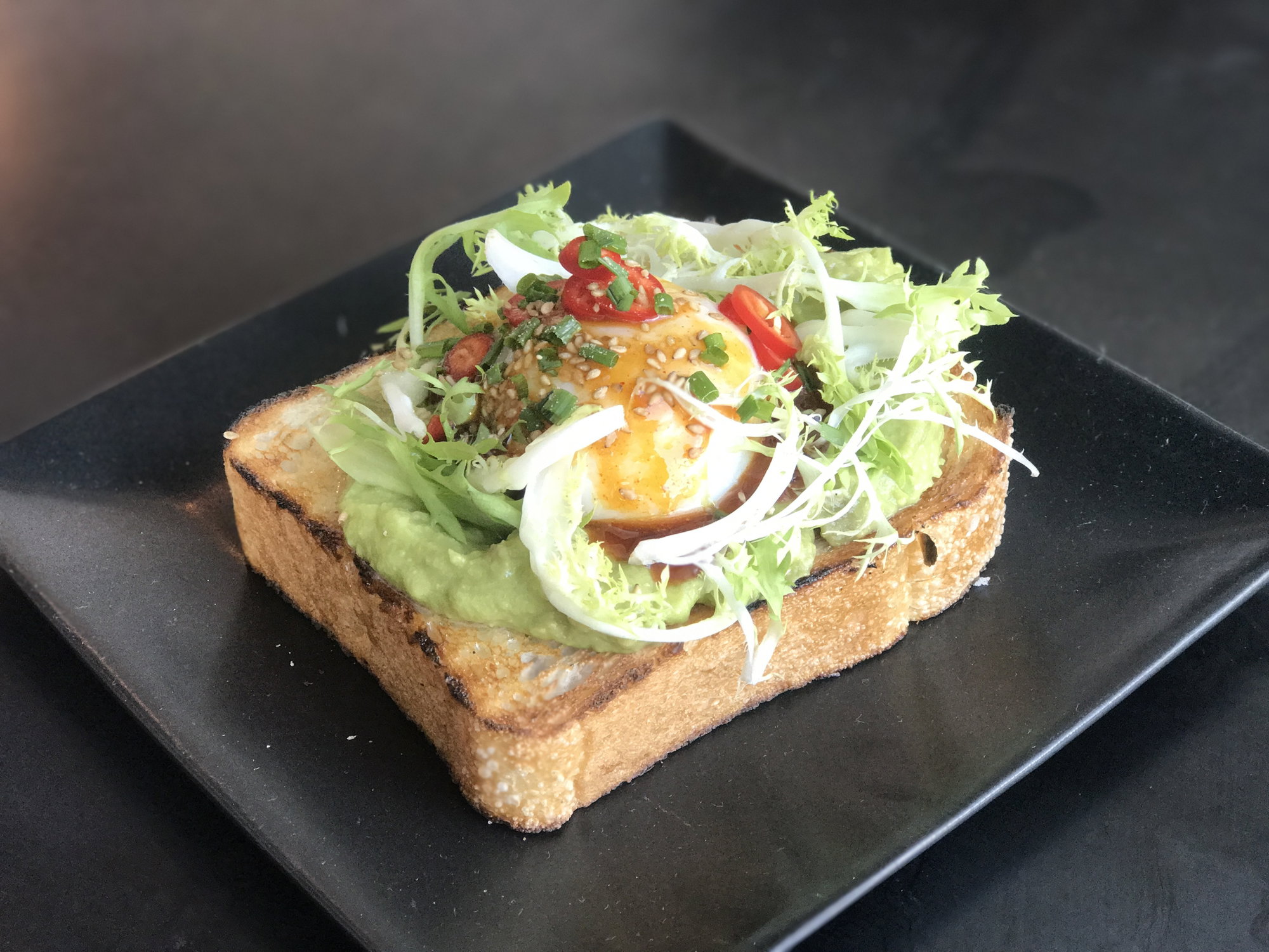 The Avo Cavo isn't your basic sister's avocado toast. Along with mashed avocado, there's frisée, a 64-degree egg and sweet-and-spicy gochujang-honey sauce atop sourdough baked by Cake & Bacon.