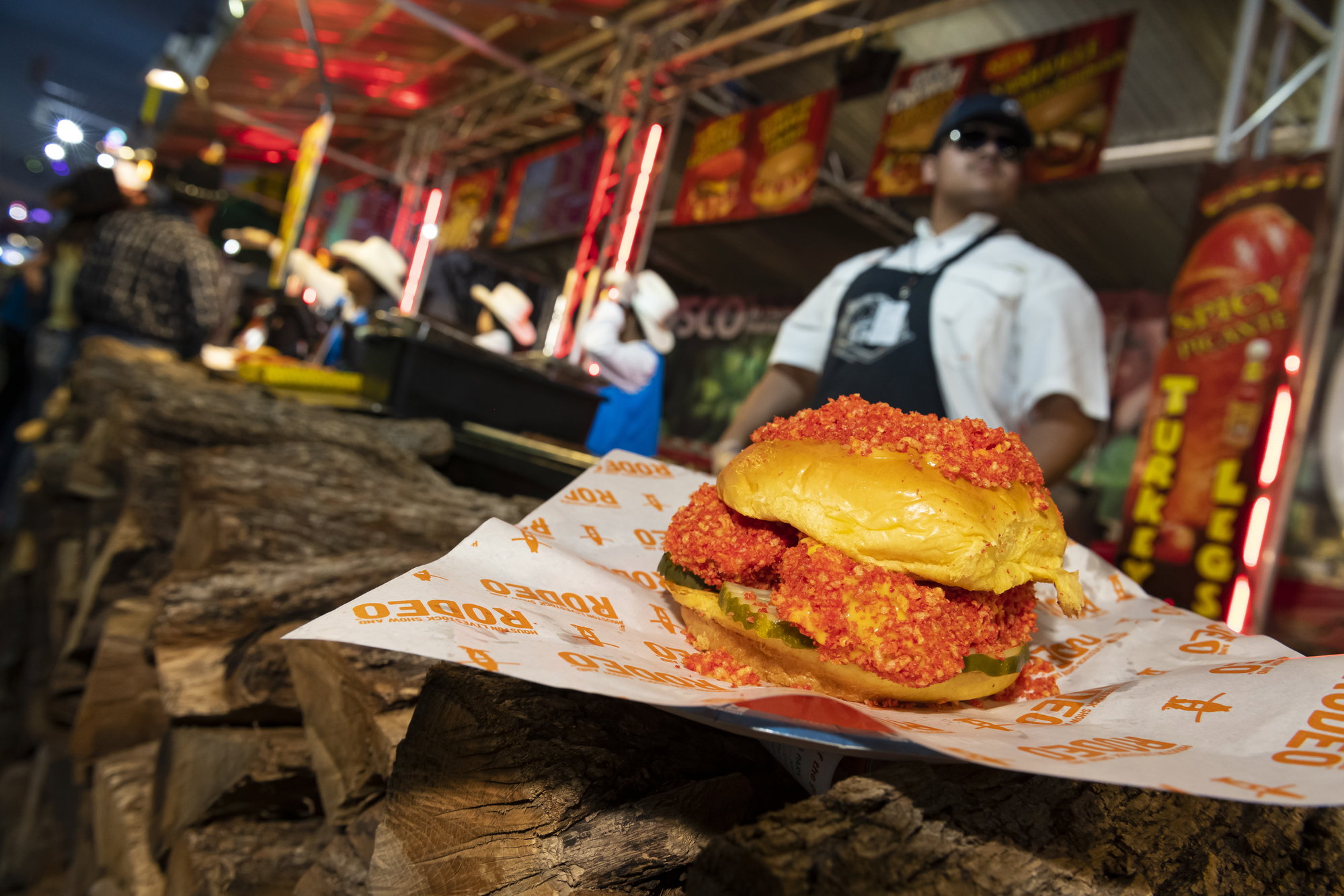 The Hot Cheetos Chicken Sandwich. A seared chicken breast filet dipped in hot melted cheddar cheese, then rolled in pulverized Flaming Hot Cheetos on a bed of four dill pickle slices, served between two butter-buns, and topped with a crumble of Flaming Hot Cheetos.