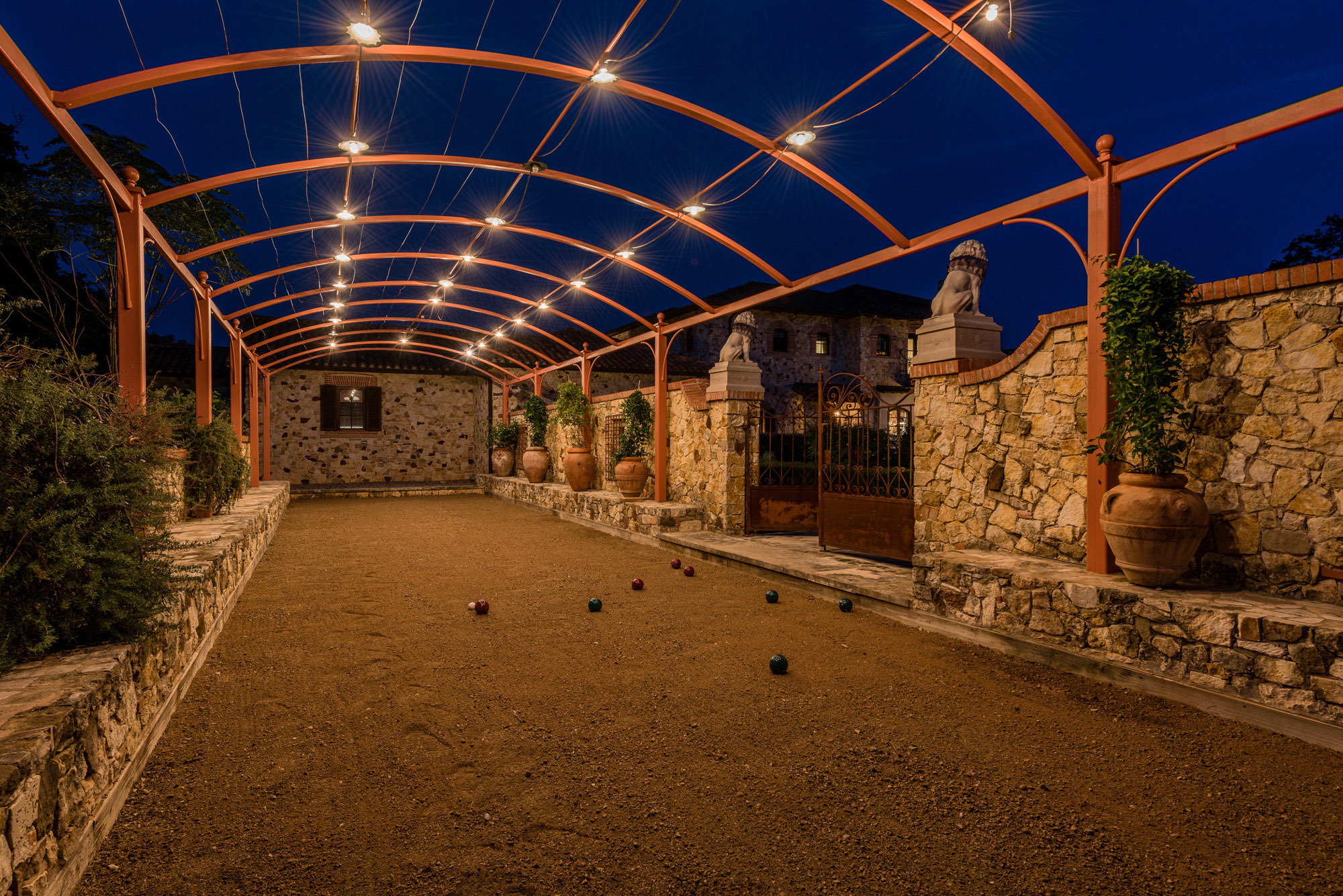 A traditional Italian bocce court is adjacent to a plain field that could be used for additional sports or hosting large events.